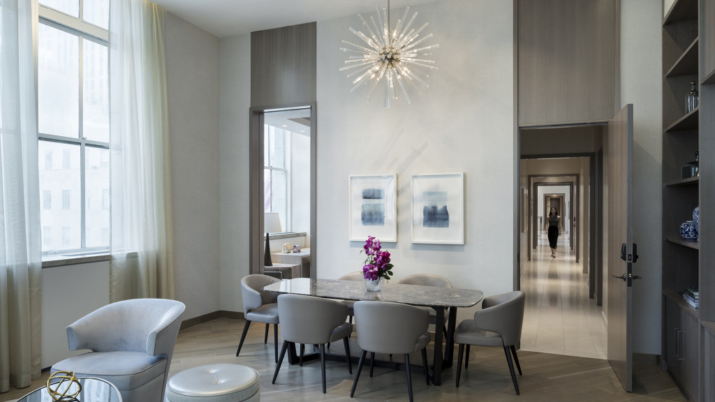 A dining room with a chandelier and a table.